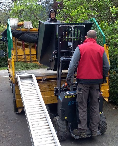 chargement de dchets vgtaux dans un camion benne avec un chariot lectrique tout terrain extramate existe galement en brouette lectrique avec conducteur accompagnant